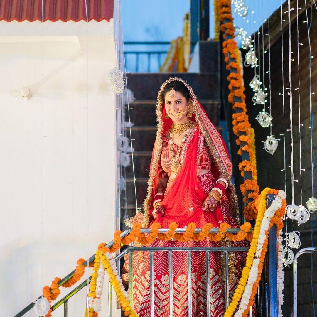 What truly elevated Sheetal's lehenga was the intricate golden embroidery that adorned it. The golden motifs, resembling blooming flowers, added a touch of grandeur and luxury to the bridal look, enhancing its visual appeal.